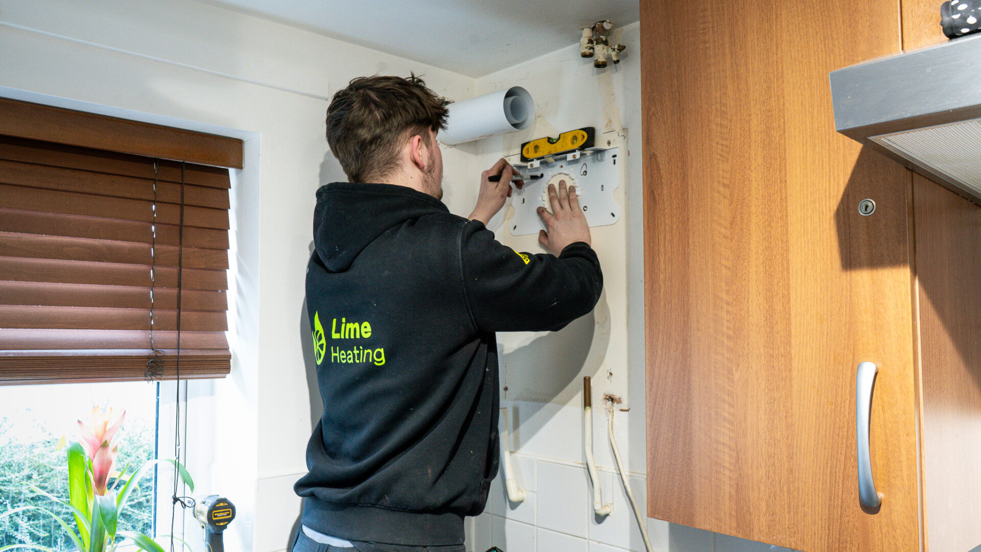 Carefully marking up the wall ready to install new gas boiler