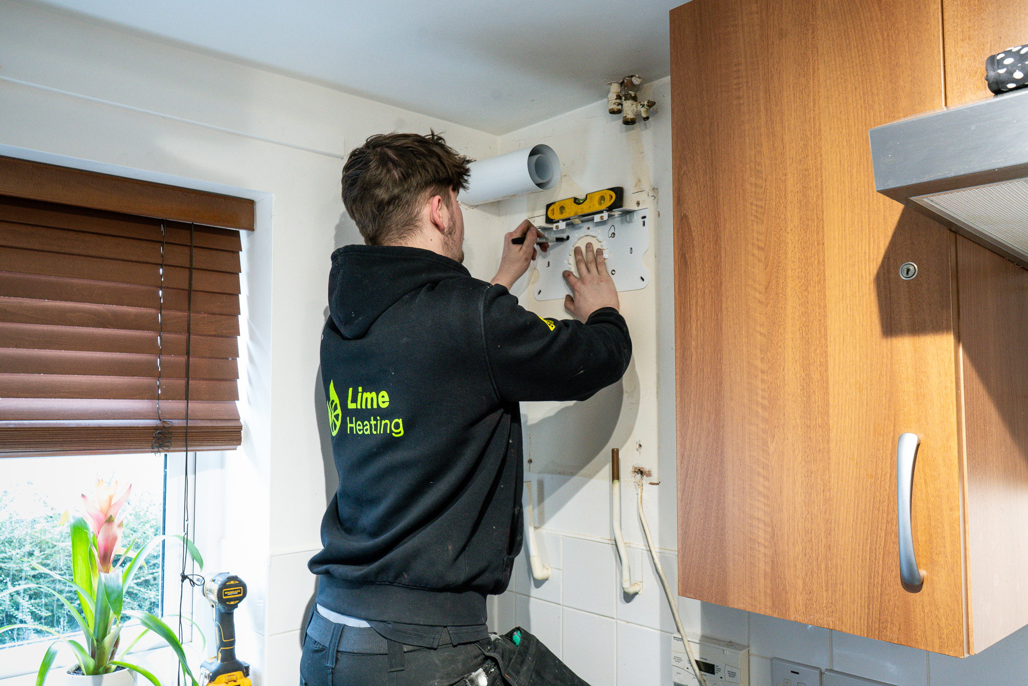 Carefully marking up the wall ready to install new gas boiler