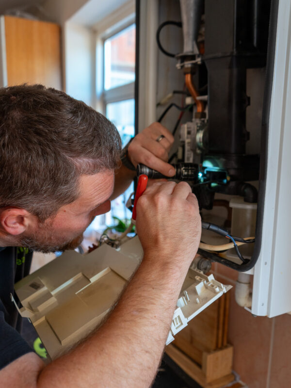 Boiler service from Gas Safe engineer, carefully inspecting parts
