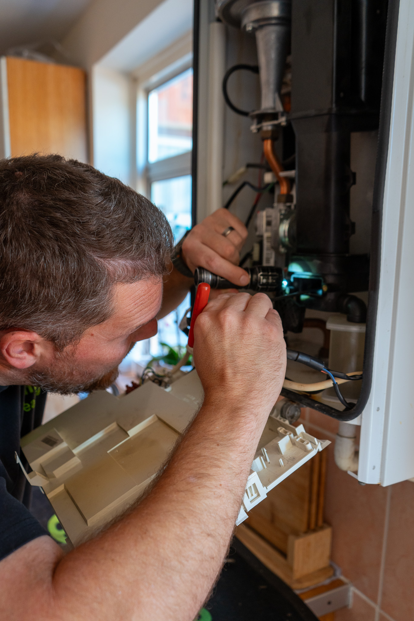 Boiler service from Gas Safe engineer, carefully inspecting parts